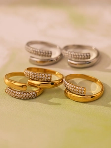 Detailed view of spiral open rings in gold and silver with shimmering 5A zircon inlay