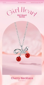 Dettaglio della collana con ciondolo a ciliegia in argento con perle rosse e fiocco
