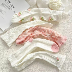 Detail von rosa und weißen Rüschensocken mit Pfirsichmuster und Jacquard-Textur