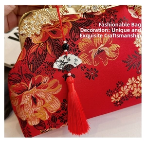 Détail du sac à main en satin rouge avec broderie florale et fermoir en métal doré