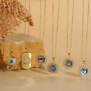 Gold evil eye necklace set with zircon pendants on artistic rock background