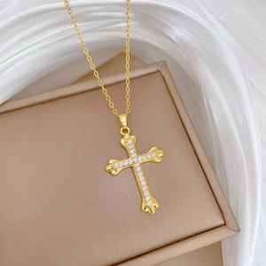 Luxurious gold cross necklace for women with white zircons on a soft silk background