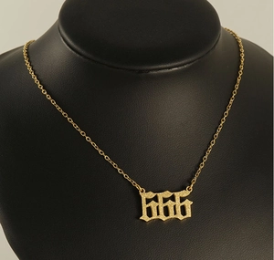 Detailed view of gold 666 angel number necklace on a black jewelry bust display