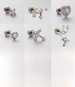 Macro shot of silver titanium steel screw back earrings with heart opal and zircon inlays