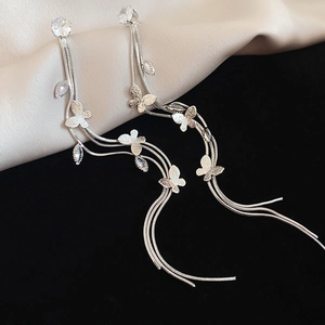 Détail de boucles d'oreilles longues à pampilles en argent avec papillons et pierres zircon