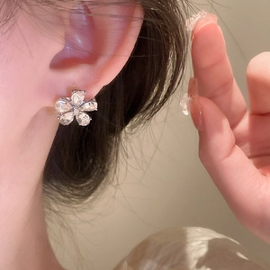 Close-up of elegant silver flower stud earring with pear-shaped cubic zirconia crystals