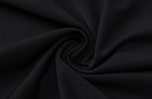 Vista macro di tessuto a maglia in poliestere nero con trama a spirale e morbido drappeggio