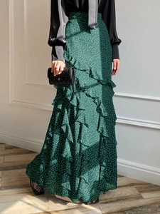 Elegant green polka dot maxi skirt with ruffle trim and flowing chiffon material