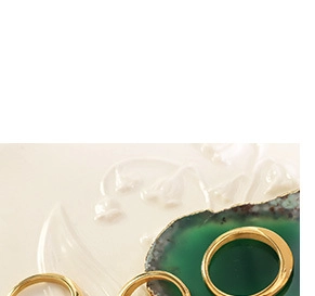 Detailed close-up of golden crown queen portrait coin rings on elegant ceramic surface