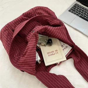 Detailed top view of red checkered tote bag showing metal snap closure and large capacity