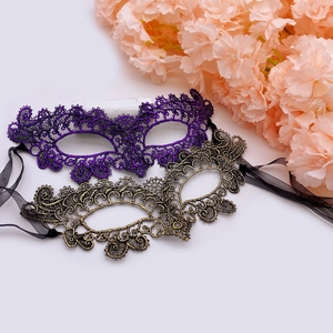 Detail of lace masquerade masks in purple and antique gold with glitter and ribbons