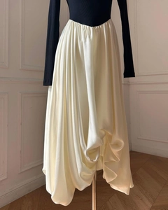 Detailed view of cream-colored oversized maxi skirt with elegant draping and black top
