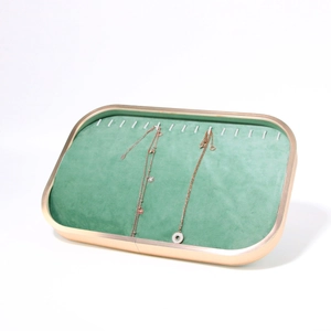 Green velvet jewelry display tray with gold metal frame and hooks for necklace storage