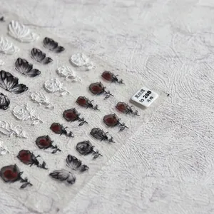 Vue détaillée de stickers d'ongles 5D en relief avec roses noires et papillons