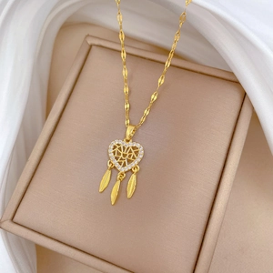 Dettaglio della collana acchiappasogni dorata con cuore in zircone e ciondoli a piuma