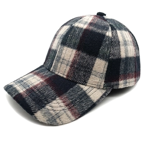 Detail of the thick wool plaid baseball cap showing the navy and grey check pattern