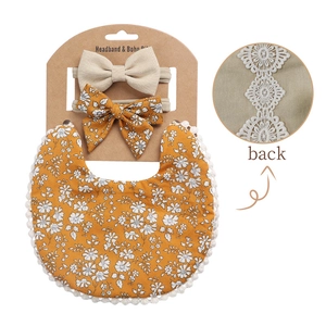 Detail of floral baby bib and headband set with decorative crochet lace edge on white background