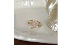 Detail of s925 silver flower ring with pink heart stone and enamel petals on white tray
