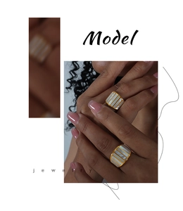 Detailed view of two wide gold bands featuring vertical white mother-of-pearl inlays