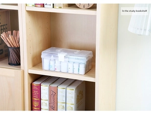 Close-up of a clear plastic storage box with handle used as a first aid kit on a shelf