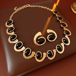 Gros plan d'un ensemble de bijoux géométriques dorés avec pierres noires sur cuir