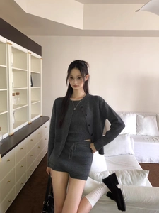 Detail of dark grey three-piece knit set featuring ribbed cardigan, vest, and drawstring shorts