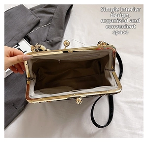 Internal view of shell clutch bag with dark lining and golden ball clasp closure
