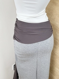 Detail of high waist contrast knit skirt showing brown pleats and grey fabric