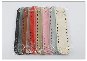 Macro view of assorted oval PU leather bag bases with metal feet and pre-punched holes