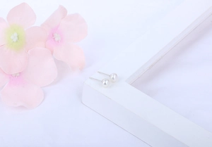 Macro detail of natural white freshwater pearl earrings with S925 silver studs