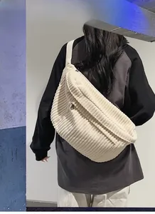 Detail of off-white corduroy crossbody bag with wide strap and thick ribbed texture