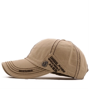 Detail view of khaki cotton baseball cap featuring vintage anchor badge and contrast stitching