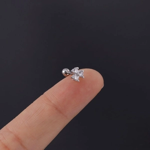 Macro shot of a small silver four-leaf clover ear stud with clear cubic zirconia stone