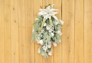 Detail of Christmas teardrop swag with snowy pine needles and Merry Christmas ribbon
