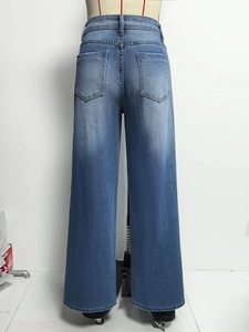Detail van de high waist wide leg jeans met achterzakken en blauw gewassen denim stof