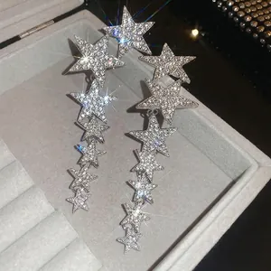 Elegant silver star tassel earrings with shimmering rhinestones in a velvet jewelry box