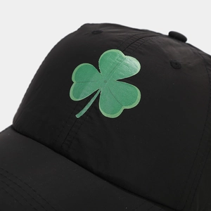 Macro shot of green clover embroidery on breathable black quick-dry baseball cap