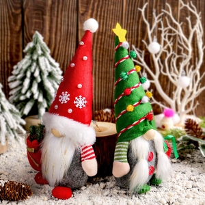 Gnomes de Noël debout avec chapeaux flocon rouge et sapin vert sur fond de bois enneigé