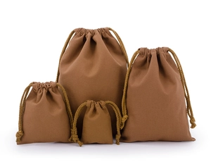 Four different sizes of brown cotton drawstring pouches showing fabric texture and design