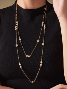 Close-up of double-layer gold necklace with large 5A cubic zirconia on a black sweater