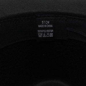 Detail view of the inner label showing 57 cm size and 100% polyester fabric material