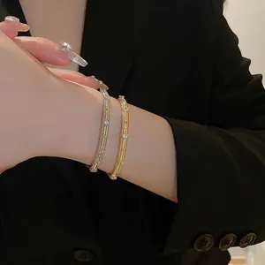 Gold and silver brushed vintage bracelets with cubic zirconia on model wrist
