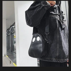 Ghost shaped black PU crossbody bag shown styled with a grey denim jacket