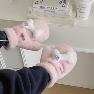 Detailed view of pink plush mittens with bone shape and purple letter embroidery detail