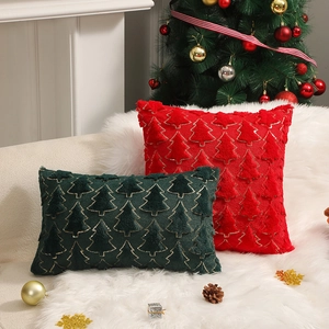 Christmas tree plush pillows in red and green displayed on a white faux fur rug