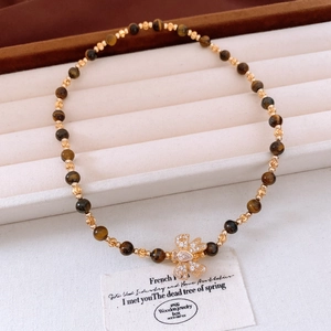 Vue détaillée du bracelet en perles d'oeil de tigre plaqué or 18 carats avec noeud