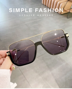Detail of oversized sunglasses with double bridge metal frame and gradient purple lenses