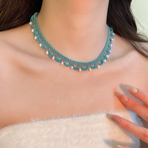 Detailed macro of a beaded stainless steel choker with sky blue and white crystals