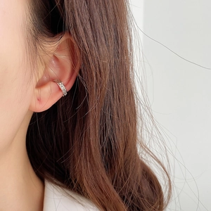 Detailed close-up of a silver 925 cuff earring with irregular wrinkled texture on ear