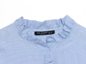 Close-up of blue and white striped poplin shirt with ruffled collar and brand label